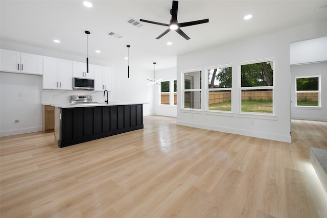 3900 De Maggio Ave, Dallas, TX 75210 - kitchen featuring stainless steel appliances, recessed lighting, open floor plan, light countertops, and white cabinets