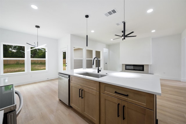 3900 De Maggio Ave, Dallas, TX 75210 - kitchen featuring stainless steel dishwasher, light wood finished floors, hanging light fixtures, recessed lighting, and a glass covered fireplace