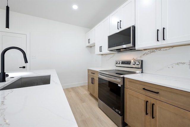 3900 De Maggio Ave, Dallas, TX 75210 - kitchen with appliances with stainless steel finishes, light stone countertops, light wood-style floors, decorative backsplash, and white cabinets