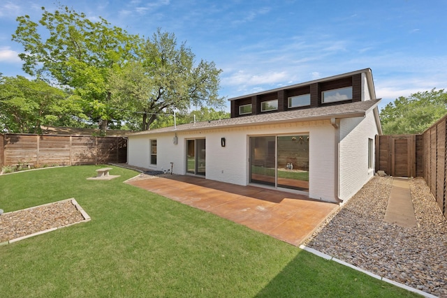 rear view of property with a shingled roof, a patio, and brick siding