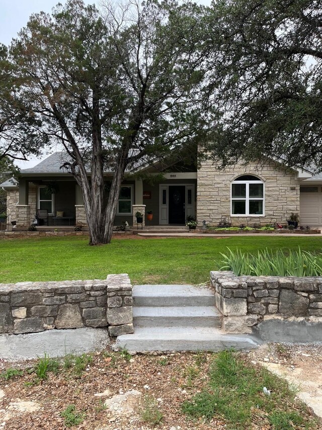 view of front of property featuring stone siding and a front lawn
