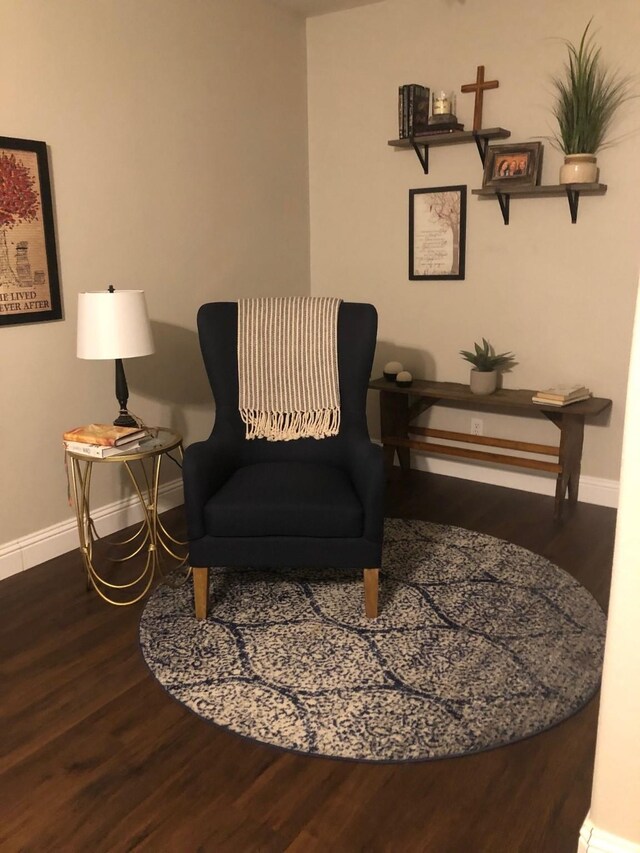 living area with baseboards and wood finished floors