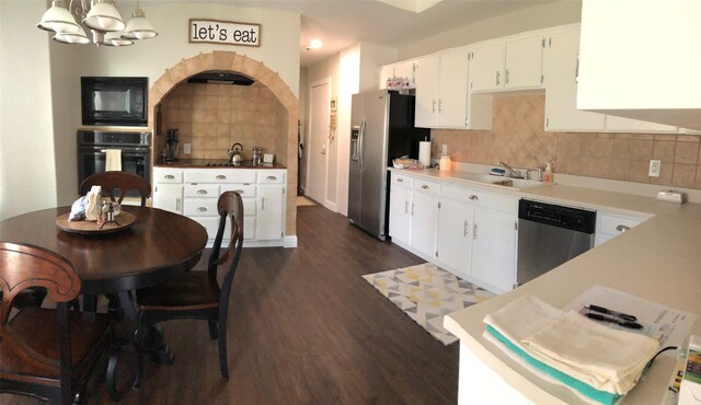 kitchen with stainless steel appliances, a sink, backsplash, and white cabinetry
