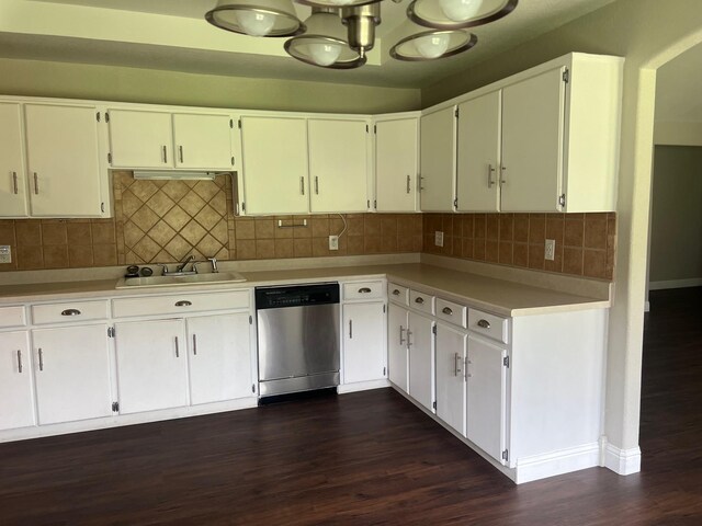 kitchen featuring dishwasher, a sink, light countertops, and dark wood-style flooring