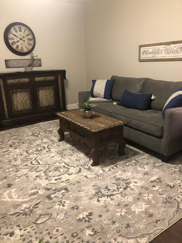 living area with baseboards and wood finished floors