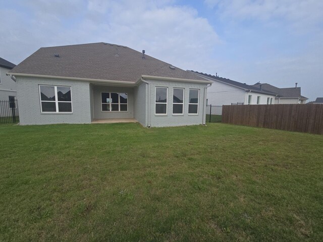 back of property with brick siding and roof with shingles