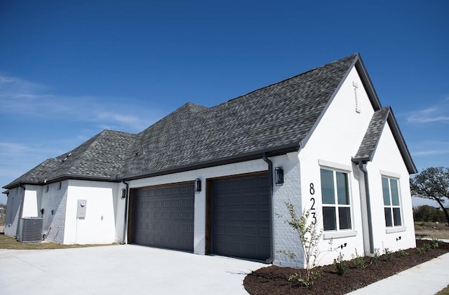 823 Wind River Pass, Azle, TX 76020 - view of property exterior with a garage, central AC, concrete driveway, a shingled roof, and stucco siding