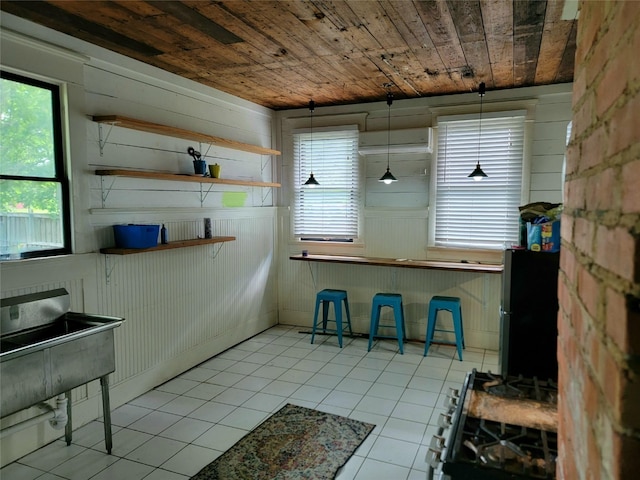 1208 W Broadway, Clarksville, TX 75426 - dining room with light tile patterned floors, wooden ceiling, and wooden walls