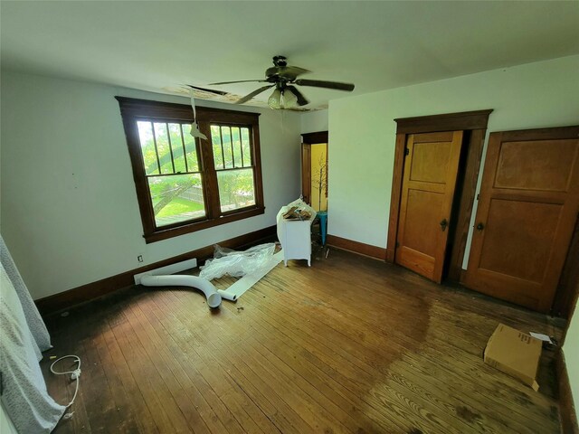 1208 W Broadway, Clarksville, TX 75426 - bedroom with baseboards, dark wood finished floors, and a ceiling fan