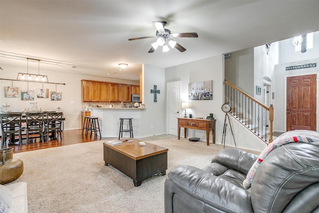 558 Ascot Way, Azle, TX 76020 - living area featuring a ceiling fan, stairway, light colored carpet, and baseboards