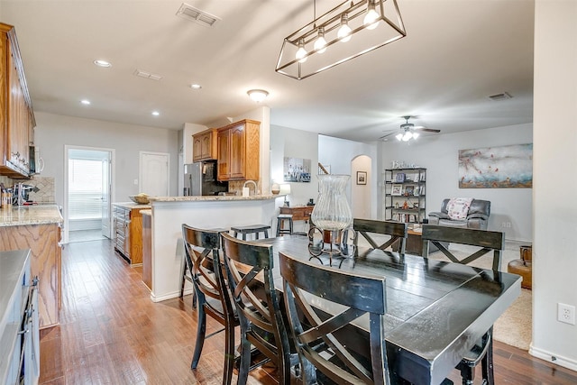 558 Ascot Way, Azle, TX 76020 - dining room featuring wood finished floors, a ceiling fan, arched walkways, and recessed lighting