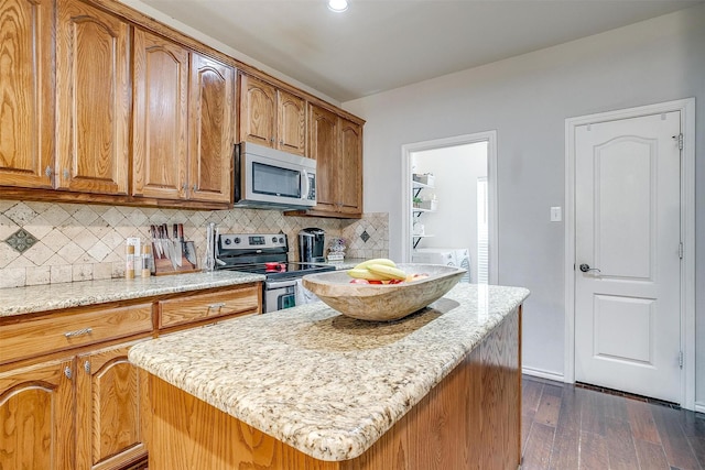 558 Ascot Way, Azle, TX 76020 - kitchen featuring appliances with stainless steel finishes, light stone counters, dark wood-style floors, tasteful backsplash, and brown cabinets