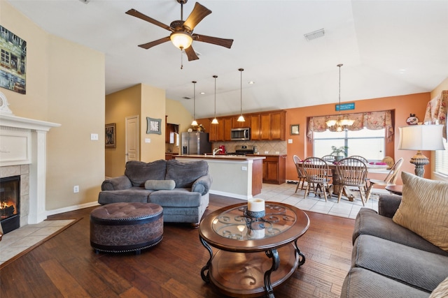 2377 Sunshine Dr, Little Elm, TX 75068 - living area with dark wood finished floors, ceiling fan, a tile fireplace, and vaulted ceiling