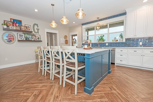 5050 Helton Rd, Justin, TX 76247 - kitchen with dishwasher, white cabinetry, light countertops, a kitchen island, and tasteful backsplash