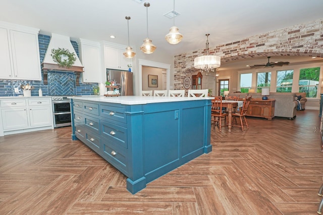 5050 Helton Rd, Justin, TX 76247 - kitchen with stainless steel appliances, premium range hood, blue cabinets, white cabinetry, and recessed lighting