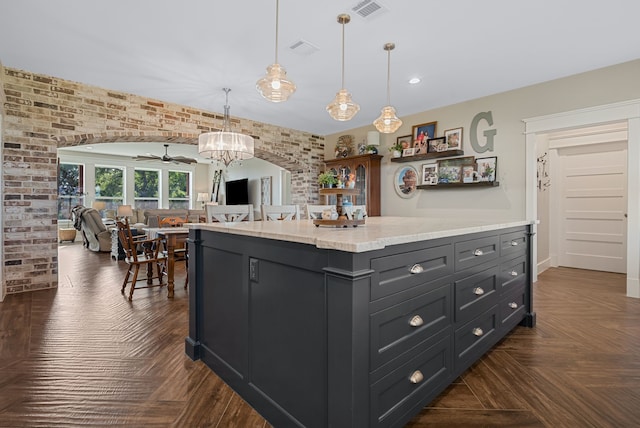 5050 Helton Rd, Justin, TX 76247 - kitchen with a ceiling fan, hanging light fixtures, open floor plan, a center island, and brick wall
