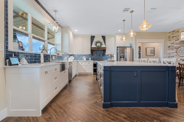 5050 Helton Rd, Justin, TX 76247 - kitchen with appliances with stainless steel finishes, premium range hood, a center island with sink, light countertops, and tasteful backsplash