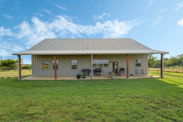 5050 Helton Rd, Justin, TX 76247 - rear view of property with board and batten siding, a patio, a metal roof, and a lawn