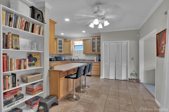 kitchen with crown molding, stainless steel dishwasher, a sink, glass insert cabinets, and light countertops