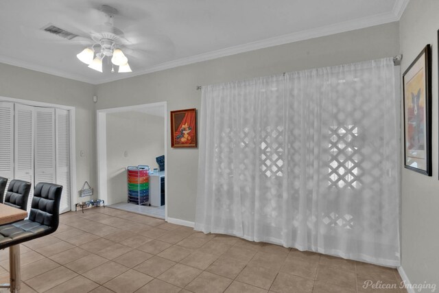 tiled dining area featuring a ceiling fan, crown molding, and baseboards