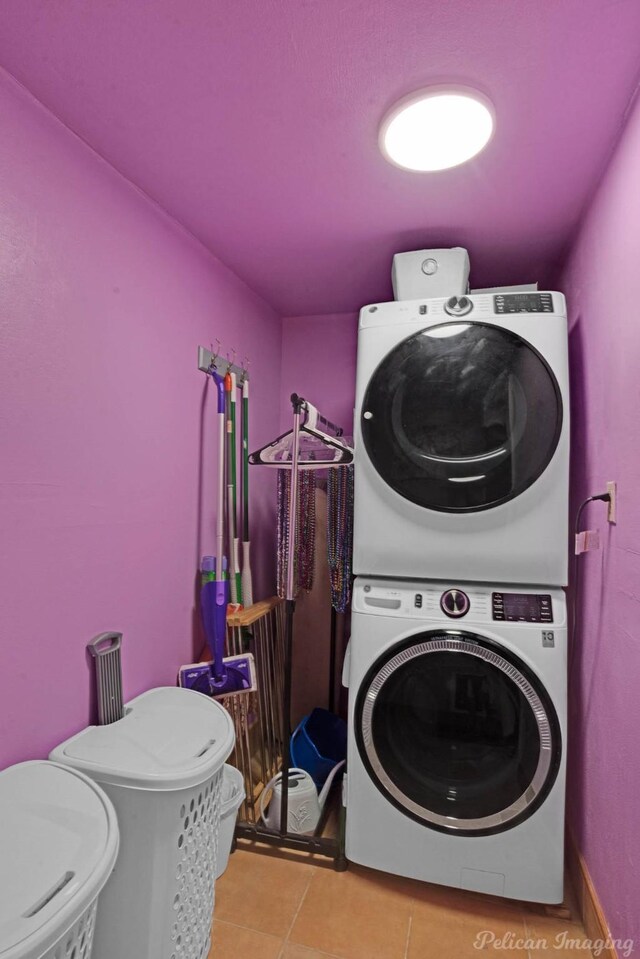 laundry room with estacked washer and dryer and tile patterned flooring