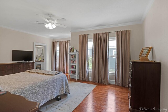 bedroom with wood finished floors, crown molding, and ceiling fan