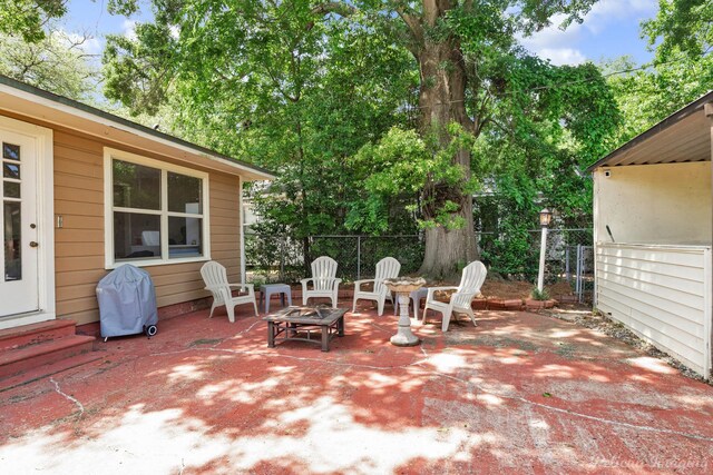 view of patio featuring fence, entry steps, and a grill