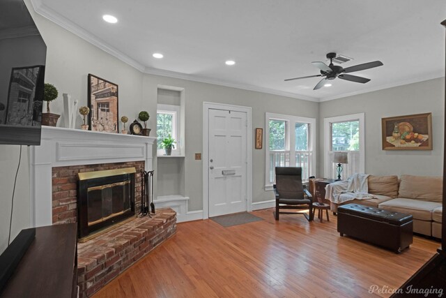 living room with a fireplace, wood finished floors, ornamental molding, a ceiling fan, and recessed lighting
