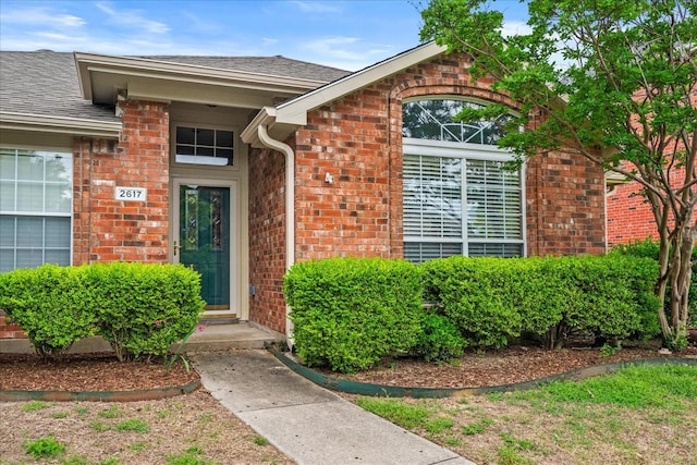 2617 Jacques Ln, Mckinney, TX 75070 - view of exterior entry featuring brick siding and roof with shingles