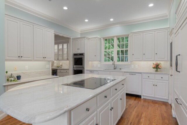 kitchen featuring black electric stovetop, dishwasher, stainless steel double oven, white cabinetry, and a sink