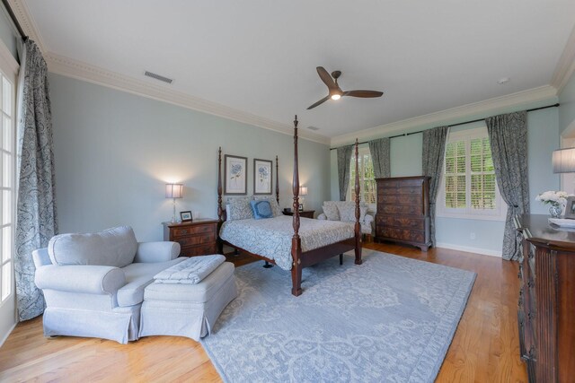 bedroom featuring ornamental molding, wood finished floors, baseboards, and a ceiling fan