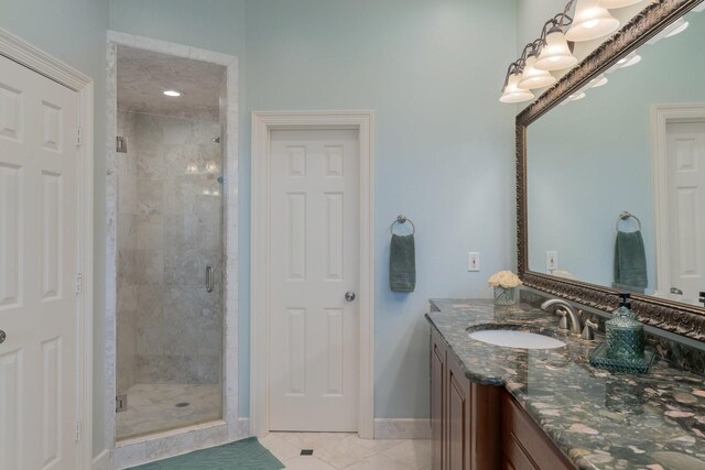full bathroom featuring tile patterned floors, a shower stall, baseboards, and vanity