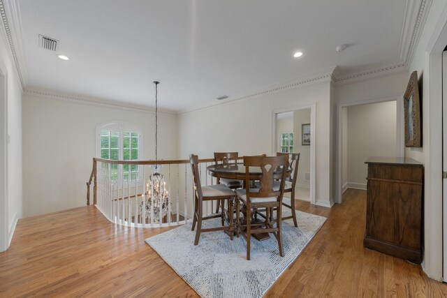 dining space with a chandelier, light wood-style floors, crown molding, and recessed lighting