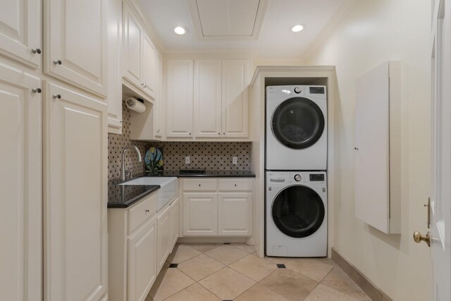 laundry room with estacked washer and dryer, light tile patterned floors, attic access, cabinet space, and recessed lighting
