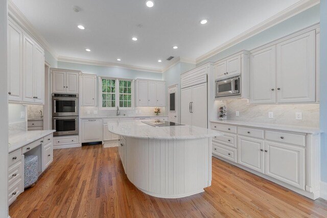 kitchen featuring appliances with stainless steel finishes, a sink, ornamental molding, backsplash, and white cabinets