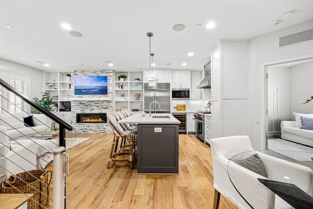 3420 Rosedale Ave Unit 6, University Park, TX 75205 - kitchen with open floor plan, built in appliances, wine cooler, light countertops, and light wood-style floors