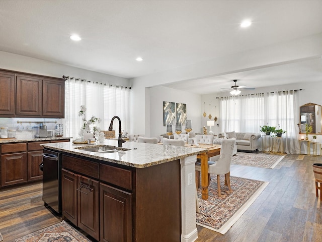 1111 Burlingame Dr, Cleburne, TX 76033 - kitchen featuring a sink, dishwasher, light stone countertops, dark wood-type flooring, and a center island with sink