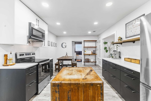 909 N 30th St, Waco, TX 76707 - kitchen with stainless steel appliances, open shelves, white cabinets, light countertops, and recessed lighting