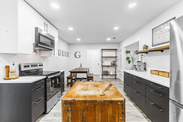 909 N 30th St, Waco, TX 76707 - kitchen with appliances with stainless steel finishes, open shelves, light countertops, white cabinetry, and recessed lighting