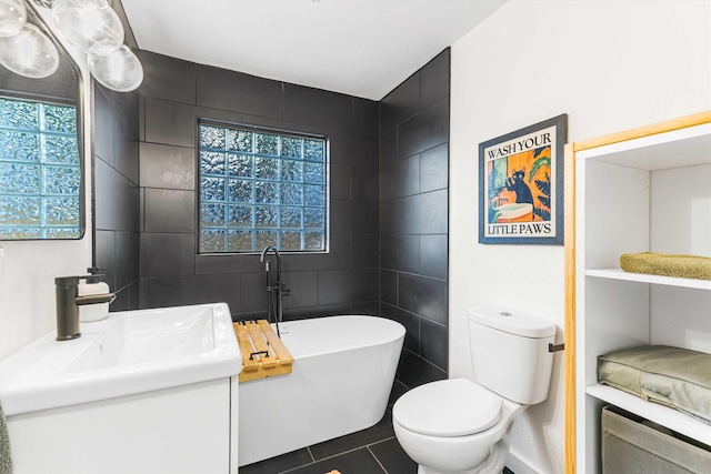 909 N 30th St, Waco, TX 76707 - bathroom with a freestanding tub, tile walls, toilet, tile patterned floors, and vanity