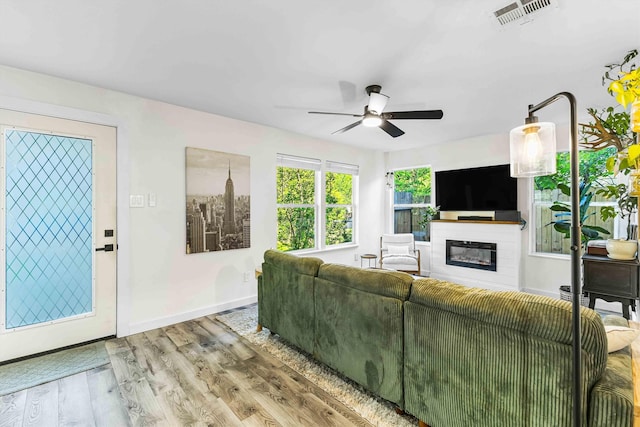 909 N 30th St, Waco, TX 76707 - living room with a glass covered fireplace, baseboards, a ceiling fan, and wood finished floors