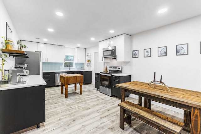 909 N 30th St, Waco, TX 76707 - kitchen featuring appliances with stainless steel finishes, recessed lighting, light wood-style floors, light countertops, and backsplash