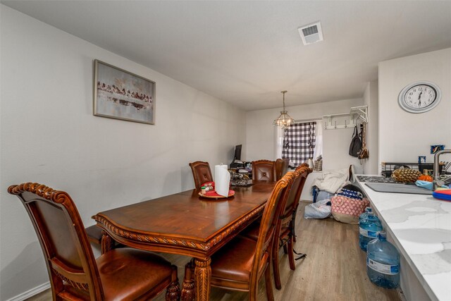 dining area featuring wood finished floors and a chandelier