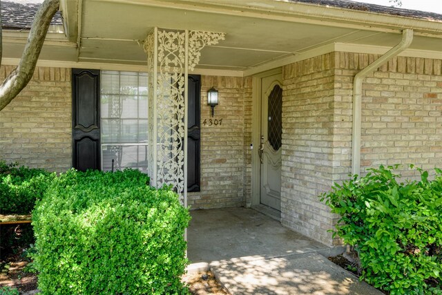 property entrance with brick siding and covered porch