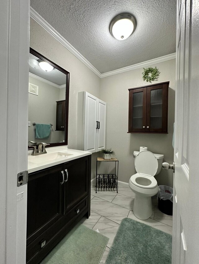 half bathroom with toilet, crown molding, marble finish flooring, vanity, and a textured ceiling