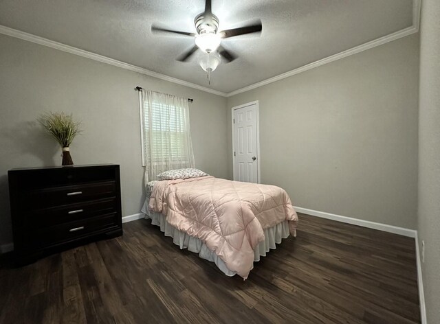 bedroom featuring dark wood-type flooring, baseboards, ornamental molding, a textured ceiling, and ceiling fan