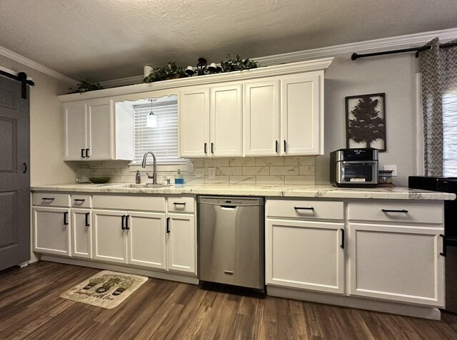 kitchen with dishwasher, crown molding, a barn door, backsplash, and a sink