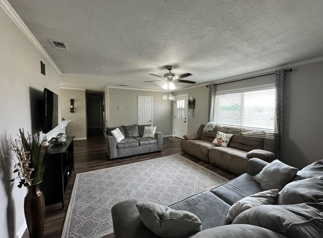 living area with baseboards, ceiling fan, a textured ceiling, wood finished floors, and crown molding