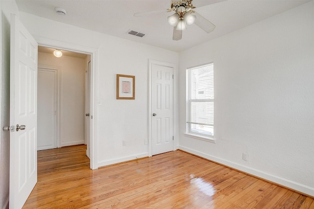 unfurnished bedroom with baseboards, light wood-style floors, a closet, and a ceiling fan