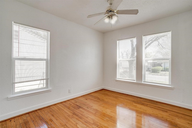 spare room featuring baseboards, light wood-style flooring, and a ceiling fan